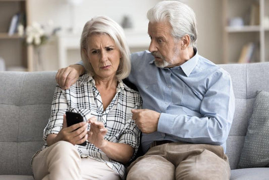 Mature woman and man searching internet on phone