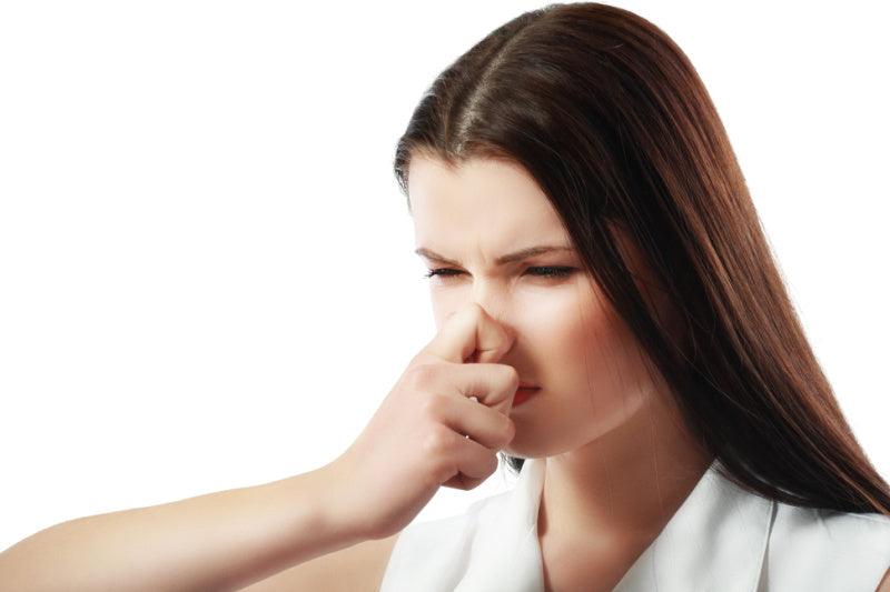 Woman holding her nose and covering her mouth